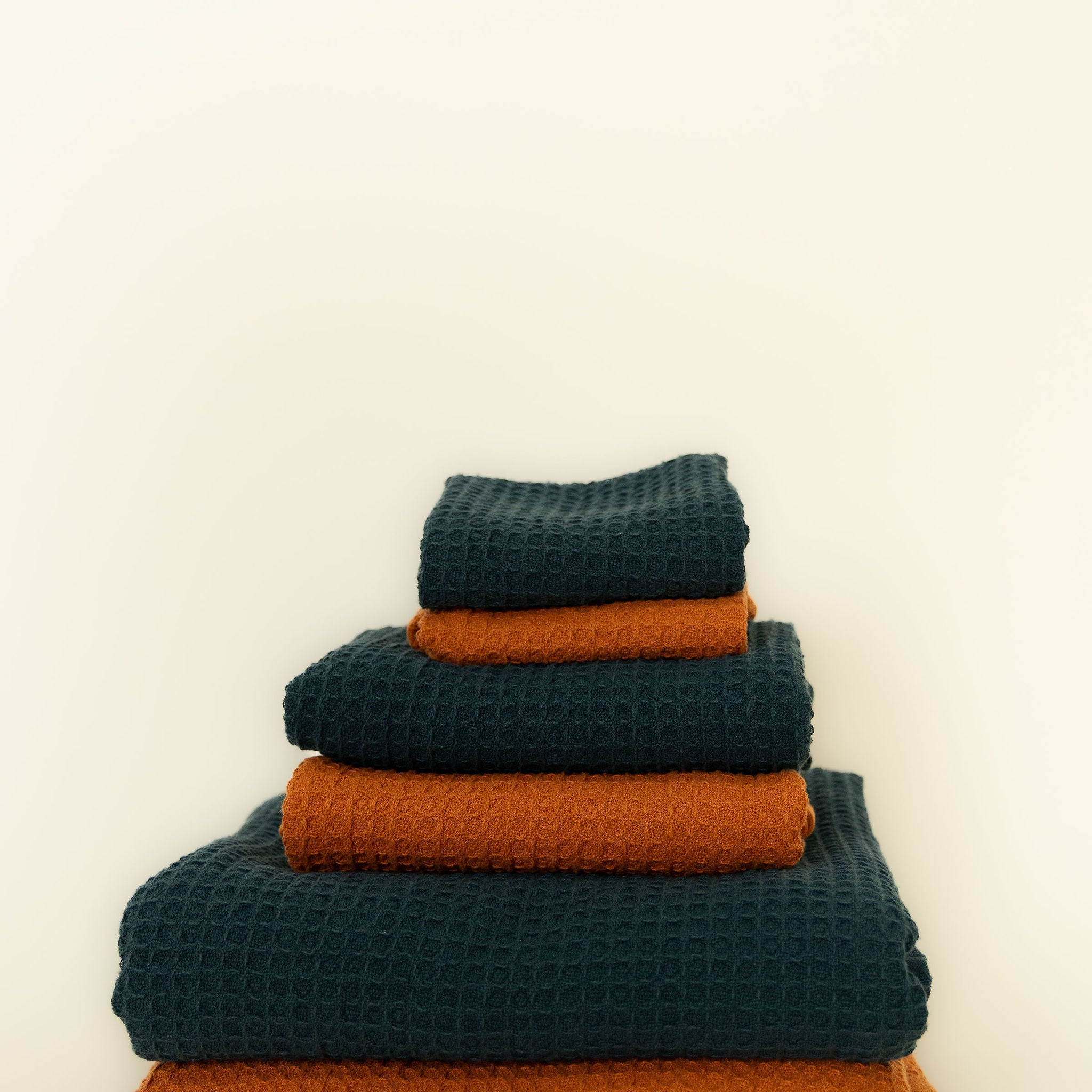 Stack of blue and orange towels on a white background