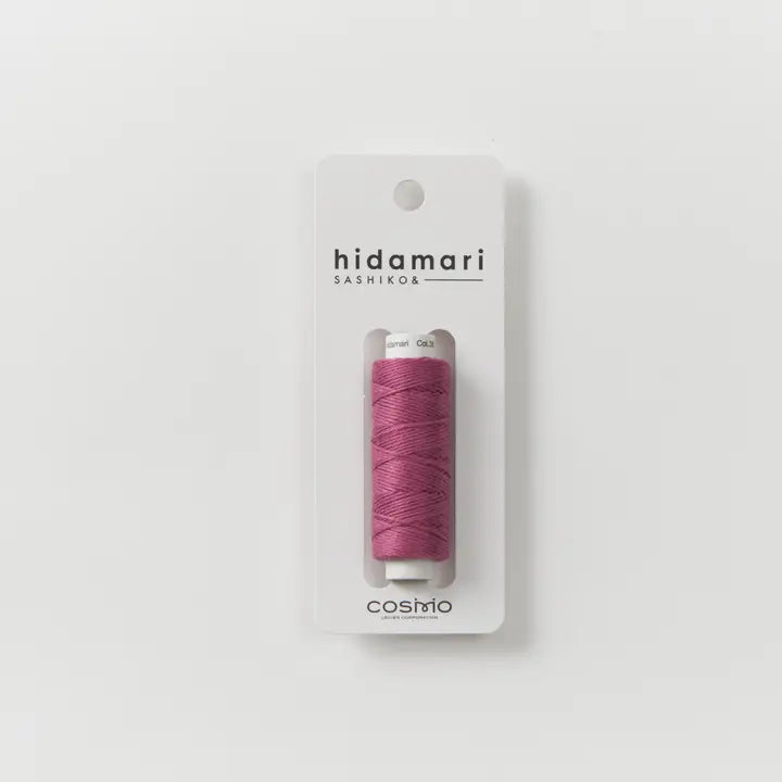 Pink thread spool on a 'hidamari sashiko' packaging with 'cosmo' branding on a white background